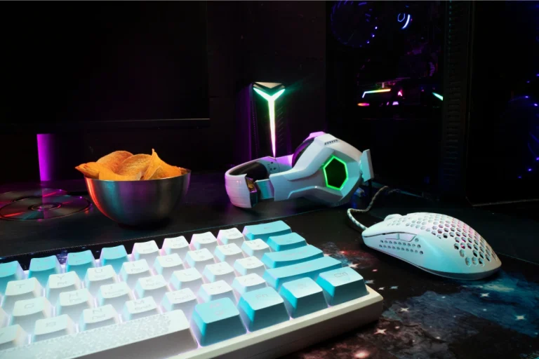 RGB-lit gaming setup with keyboard, mouse, headphones, and galaxy-themed desk pad