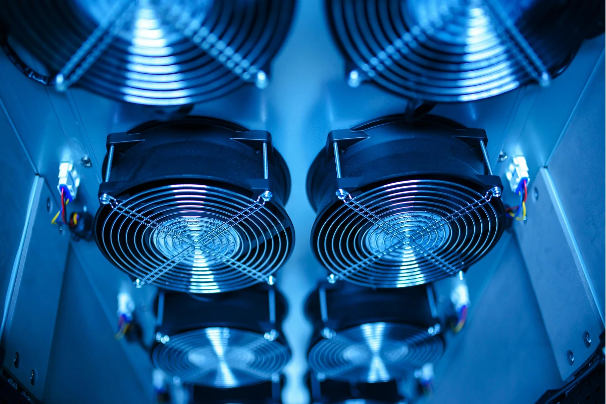 Grid of cooling fans in a server rack, illuminated with blue lighting.